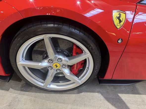 Detailed red sports car wheel and glossy paint